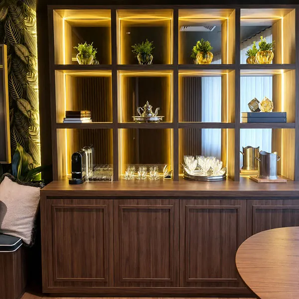 Buffet planejado em madeira com nichos iluminados e portas frisadas na sala de jantar